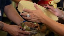 Sheila López finaliza la bendición del tambor. Lo hace quemando salvia en un caparazón de abulón. (Foto por Annika Tomlin/Cronkite Noticias)