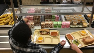 In this Jan. 25, 2017, file photo, students fill their lunch trays at J.F.K Elementary School in Kingston, N.Y., where all meals are now free under the federal Community Eligibility Provision. A donor inspired by a tweet raised money to pay off lunch debt in districts around the country, as well as thousands of dollars in overdue lunch fees at other schools in the Kingston district.