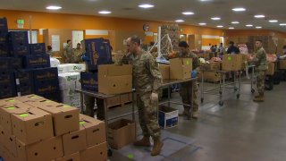 Members of the National Guard fill food boxes at Second Harvest Food Bank.