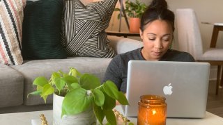 A woman works from home with a laptop computer.