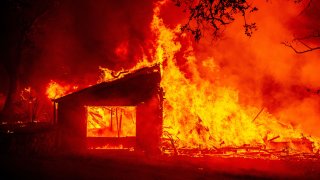 In this Sept. 27, 2020, file photo, a building burns during the Glass fire in St. Helena, California.