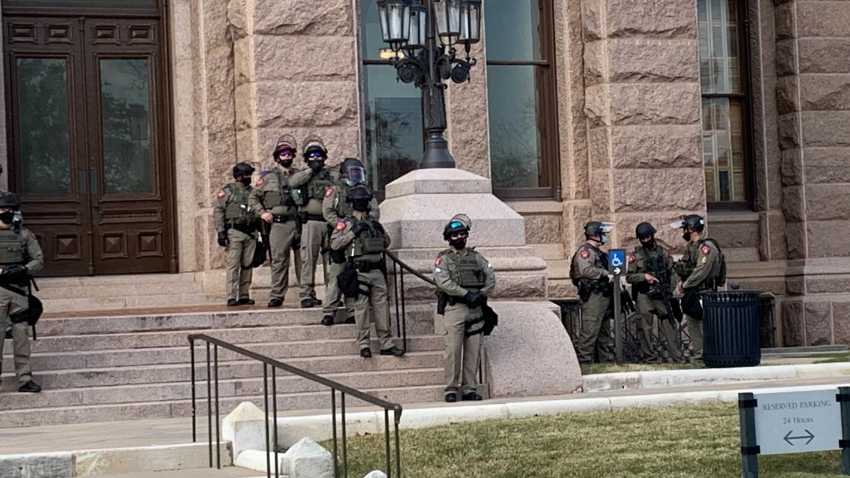 More than 100 Texas troopers, including dozens wearing tactical vests and carrying riot gear, stood on guard outside the state Capitol on Tuesday as lawmakers returned to work amid FBI warnings of armed protests at statehouses across the country.