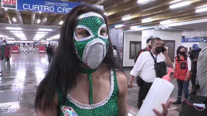 Luchadores mexicanos reparten cubrebocas en el transporte público