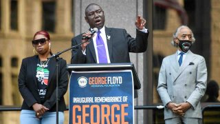 El abogado Ben Crump (C) habla ante cientos de simpatizantes mientras comparte escenario con el reverendo Al Sharpton (D) y Bridgett Floyd (I), hermana de George Floyd, en un mitin en Minneapolis, Minnesota.