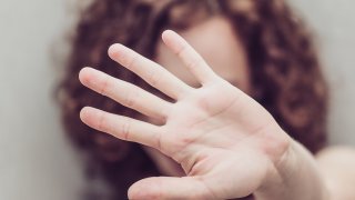 A stock photo of a woman making a stop gesture.