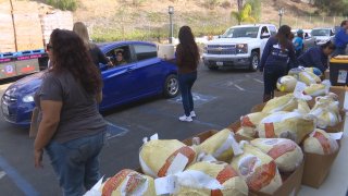 Cars drive by a table covered with turkeys