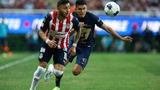 Alexis Vega (i) de Chivas disputa el balón con José Galindo (d) de Pumas hoy, durante un partido de reclasificación del torneo clausura 2022 de la liga de fútbol mexicano disputado, en el Estadio Akron, en Guadalajara, Jalisco (México).