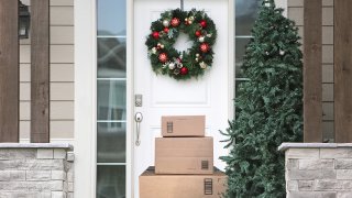 foto de archivo. puerta de entrada con corona de navidad y paquetes.