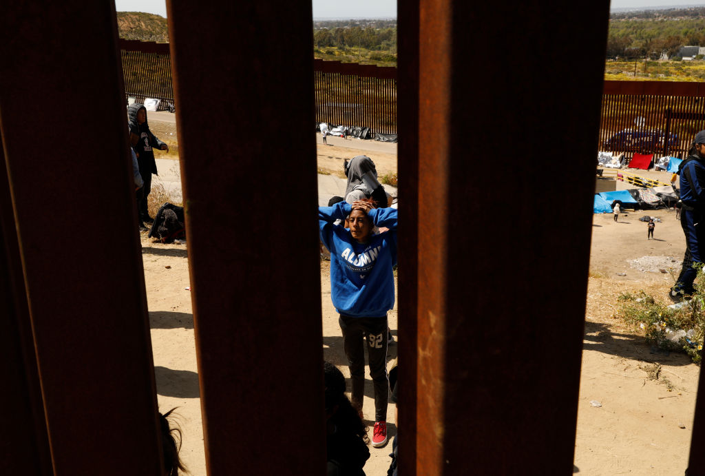 Migrantes que esperan cruzar a los Estados Unidos desde Tijuana, México, esperan en un área al sur del segundo muro fronterizo en previsión de un cambio en la política de inmigración, el Título 42, que puede permitirles solicitar asilo. El cambio está programado para entrar en vigencia a la medianoche del 11 de mayo de 2023. (Carolyn Cole / Los Angeles Times a través de Getty Images)