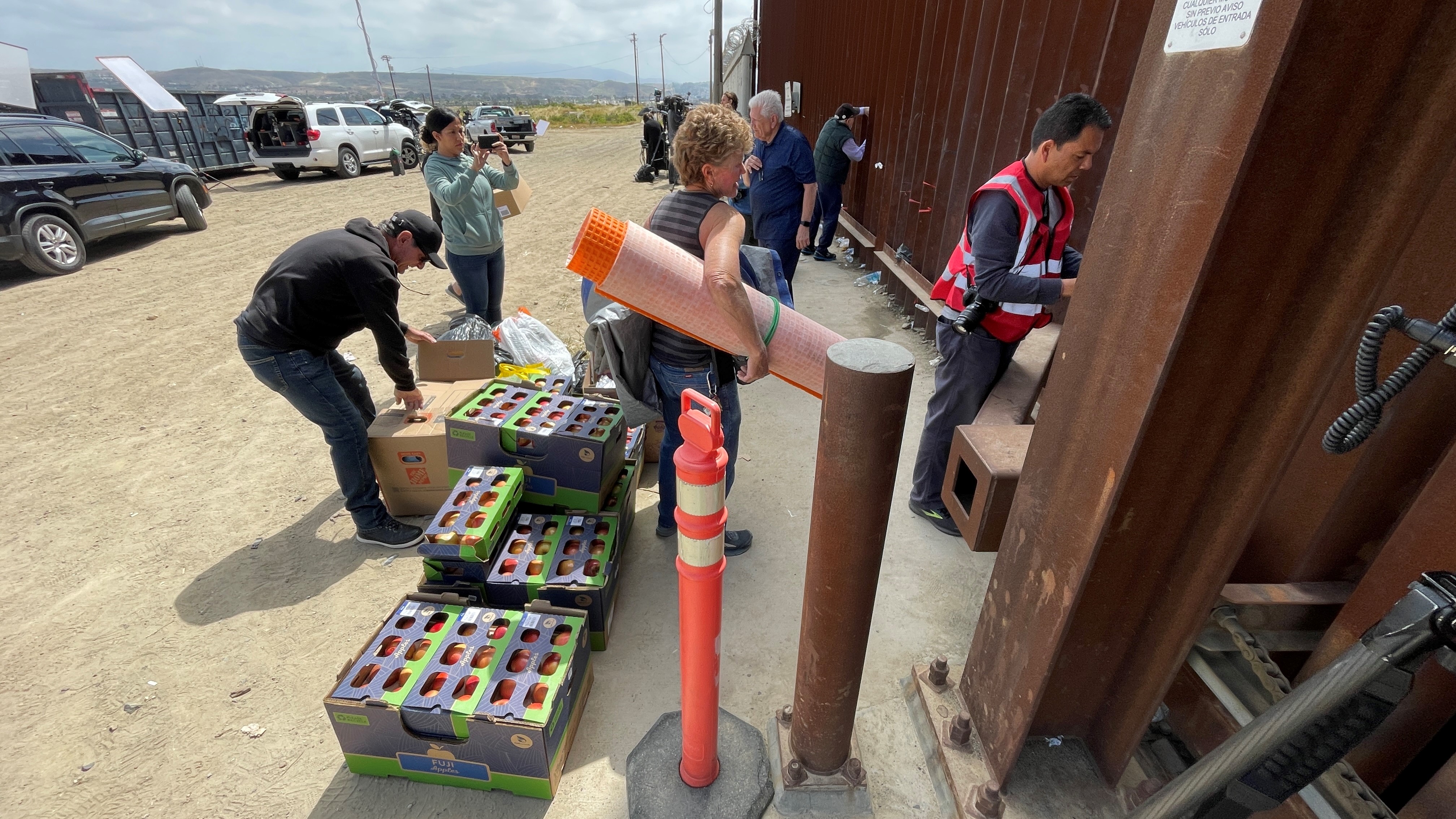 Los voluntarios entregan suministros a los migrantes en la frontera entre Estados Unidos y México en San Ysidro el 11 de mayo de 2023, horas antes de que expire el Título 42.