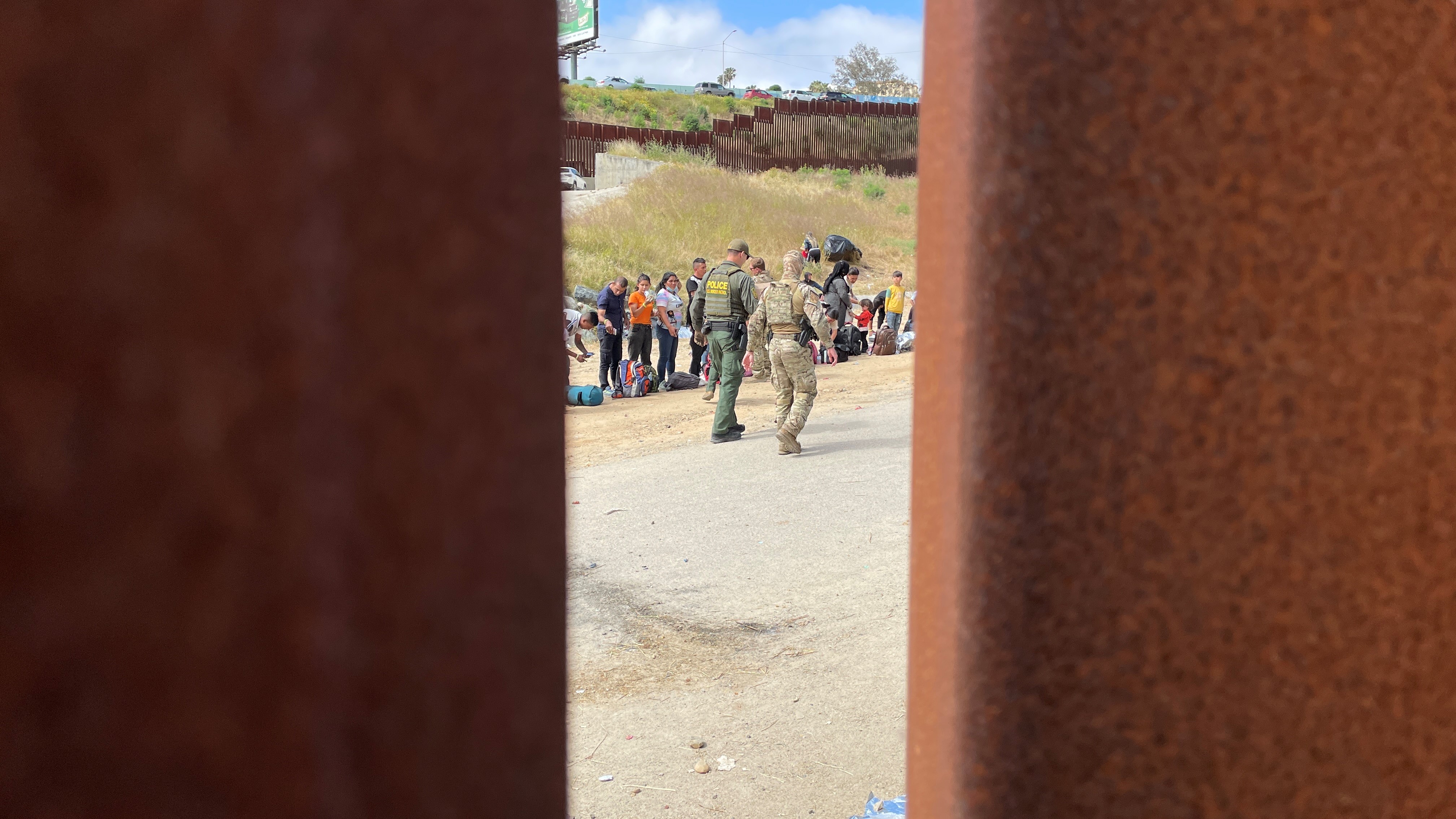 Desde la frontera entre EEUU  y México, un agente de la patrulla fronteriza de EEUU supervisa a los migrantes cerca de San Ysidro el jueves 11 de mayo de 2023.