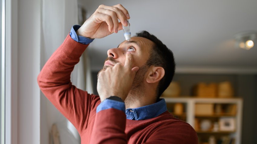 Close-up of young man applying eye drops to treat dry eye and irritation at home