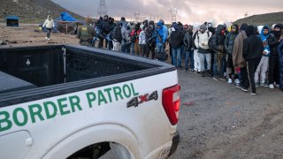 Solicitantes de asilo aguardan cerca de la frontera, en San Diego, para ser procesados por personal de ICE.