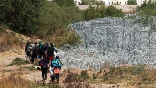 Migrantes se reúnen en la frontera entre México y Estados Unidos.