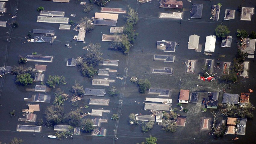 EN VUELO – 30 DE AGOSTO: Un helicóptero de la Guardia Costera estadounidense sobrevuela un barrio inundado al este del centro de Nueva Orleans el 30 de agosto de 2005. Se teme que hayan muerto unas 100 personas y se calcula que las pérdidas materiales ascienden a casi $30,000 millones, por lo que el huracán Katrina podría convertirse en la tormenta más costosa de la historia de Estados Unidos. Se calcula que el 80% de Nueva Orleans está bajo las aguas de las inundaciones, ya que los diques empiezan a romperse y a tener filtraciones alrededor del lago Ponchartrain. (Foto de Dave Einsel/Getty Images)