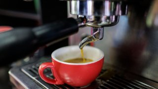 Una mujer prepara café en una cafetera.