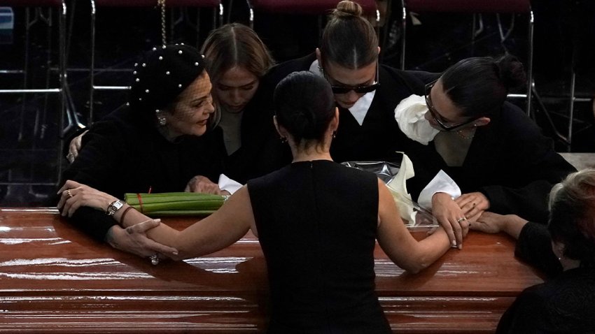 Miembros de la familia de Silvia Pinal se reúnen alrededor del ataúd que contiene los restos de la actriz mexicana, durante su funeral. (Foto AP/Aurea Del Rosario)