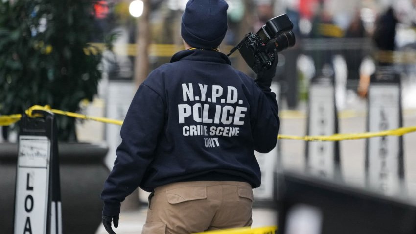 A Crime Scene Unit officer photographs the scene where CEO of UnitedHealthcare Brian Thompson, 50, was shot as he entered the New York Hilton early on December 4, 2024 in New York.