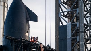 Empleados inspeccionan la nave SpaceX Starship Flight 8 cerca de la plataforma de lanzamiento orbital A antes de su lanzamiento en la playa de Boca Chica el 03 de marzo de 2025 en Boca Chica Beach, Texas.