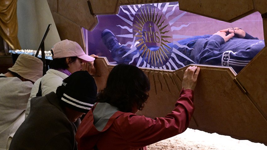EDITORS NOTE: Graphic content / Faithful pray in front of the tomb of Blessed Carlo Acutis,  an adolescent who spent his life spreading his faith online, earning the moniker “God’s Influencer”, in the Shrine of the Renunciation in Assisi, part of the Church of Saint Mary Major, on April 3, 2025. Blessed Carlo Acutis, the world’s first millennial saint who died in 2006 aged 15, will be canonized by Pope Francis on April 27, 2025 in The Vatican. (Photo by Tiziana FABI / AFP) (Photo by TIZIANA FABI/AFP via Getty Images)