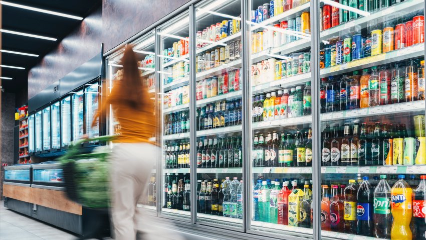 Blurred motion of energetic people on the move while shopping in a grocery store. Blurred shot of some customers pushing their shopping trolley while looking for groceries in local supermarke